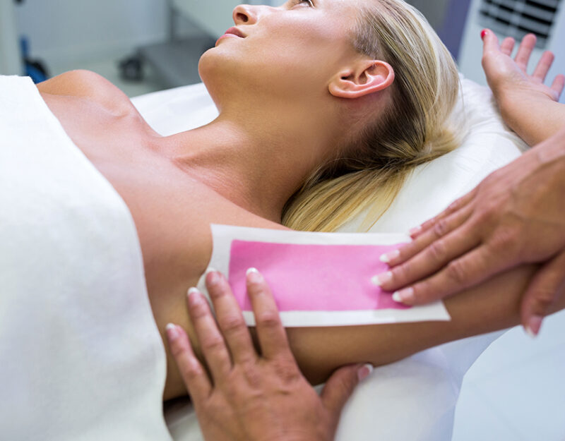 Woman getting her armpit hair removed at beauty salon